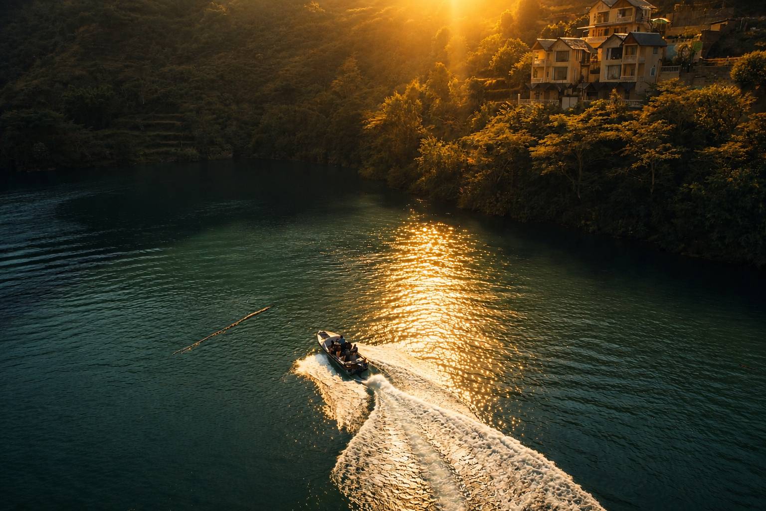 Wooden boat crossing the still waters of Chamera Lake toward Panchtatva Lake Retreat